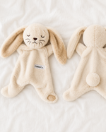 Two beige plush toys resembling bunnies on a white background
