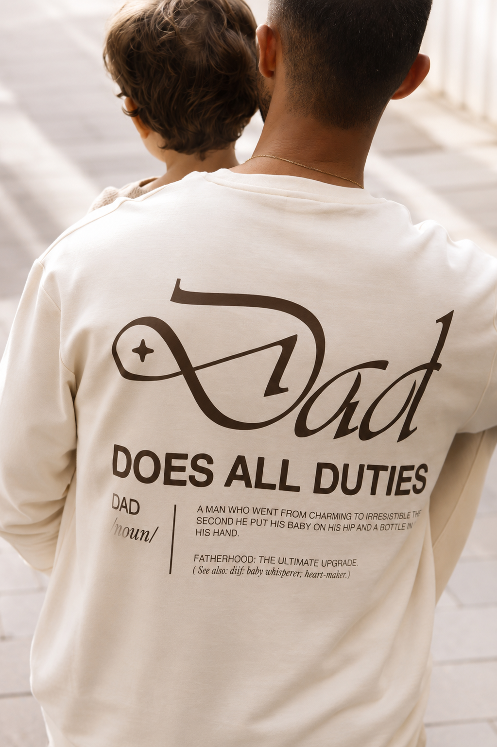 Person wearing a shirt with 'Dad does all duties' text on the back.