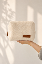 Boucle textured pouch held by a hand with a neutral background