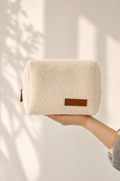 Boucle textured pouch held by a hand with a neutral background