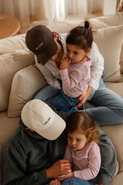 Two adults and two children sitting on a couch in a cozy living room.