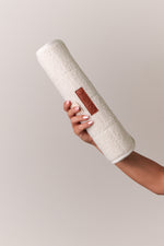 white boucle change pad rolled up being held