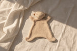 Lamb teddy cuddly on a textured beige surface