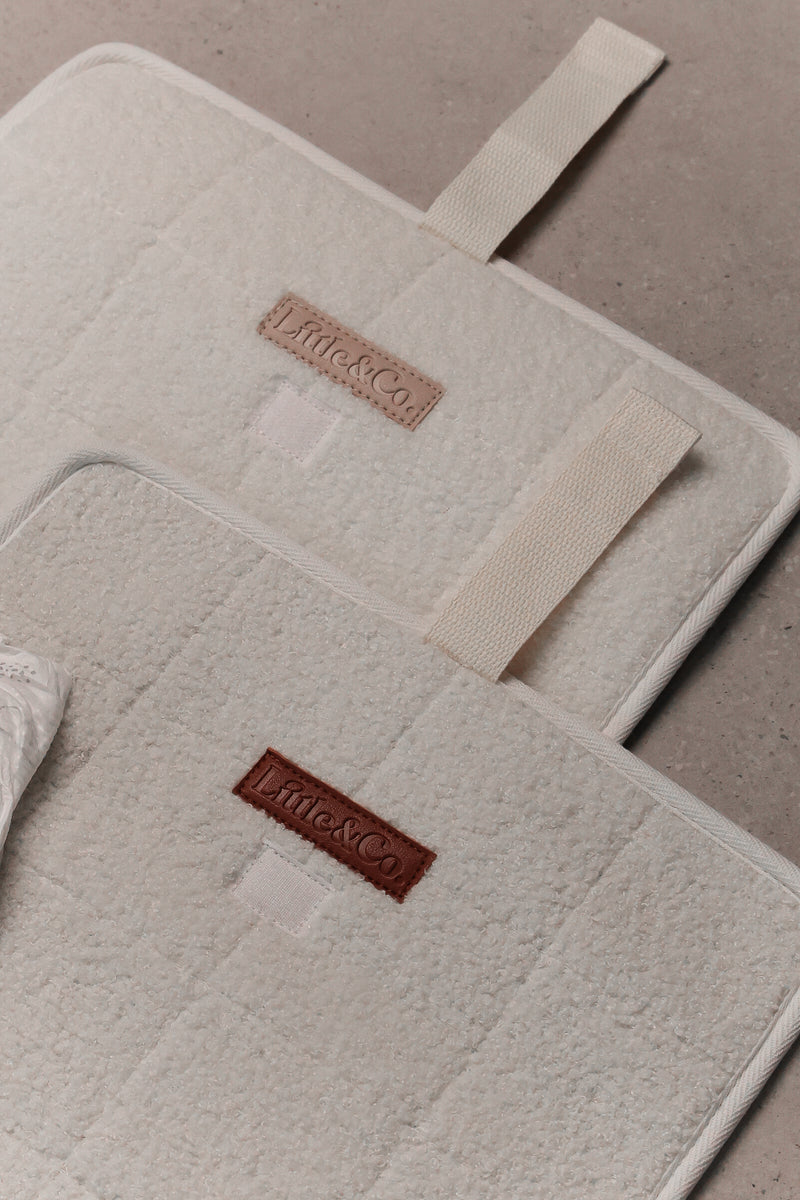 2 Boucle change pads one with cream leather logo and one with a brown leather logo