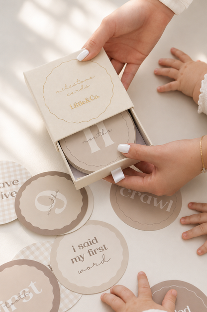 Milestone Card set with text on a table, held by hands