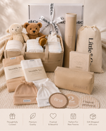 Newborn essentials 10 piece bundle with toys and baby items on a soft surface.