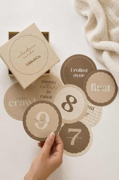 Baby milestone cards with text and a box labeled 'Little & Co' on a light background.