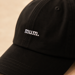 Black cap with 'mum.' embroidered on a beige background