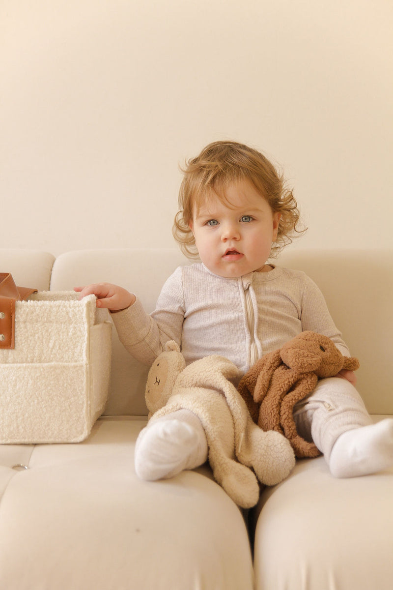 toddler with lamb and teddy cuddly in her lap